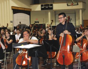 Dodge City High School cellist Rony Castro Lux receives a round of applause at the May 8 concert when Orchestra Director Jane Lindamood said he had earned a seat on the state orchestra. [PHOTO BY Whitney Hodgin/Dodge City Globe]